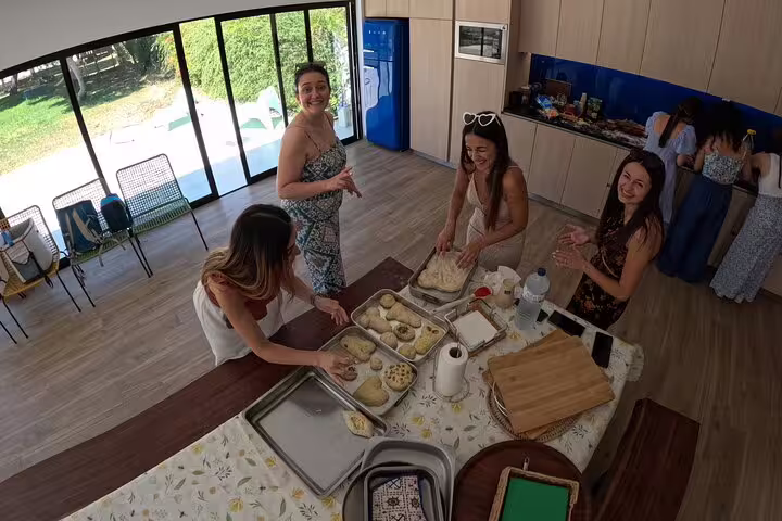 Guests enjoy a hands-on bread-making workshop, crafting dough creations in a sunlit kitchen during the Bread, Wine&Cheese tour.