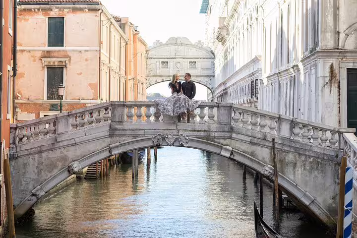 Bride and groom on Venetian canal bridge near Bridge of Sighs, luxury Venice wedding photography tour