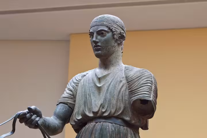 Bronze Charioteer of Delphi statue at the Archaeological Museum, a highlight on private day trip from Athens
