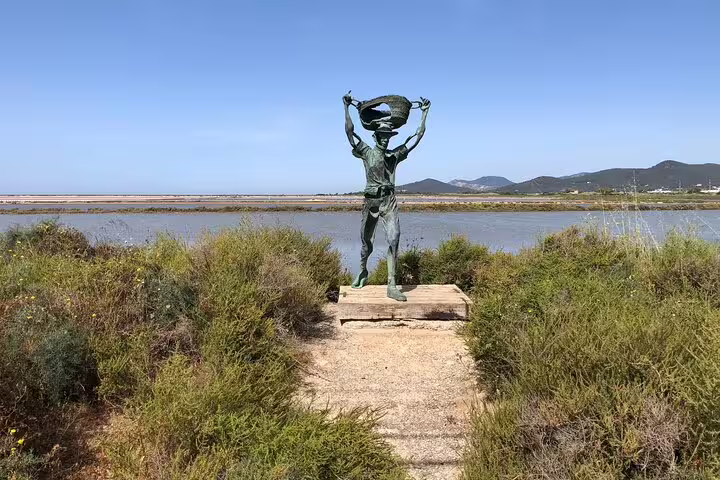 Bronze fisherman statue by Ibiza salt flats, scenic stop on Ibiza island tour by bus with official guide