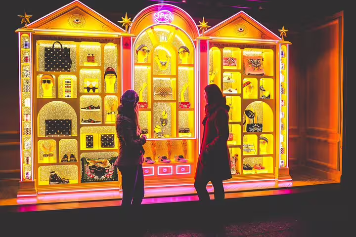 Travelers pose by a neon-lit Brooklyn storefront window display, perfect for a DUMBO photo tour in NYC