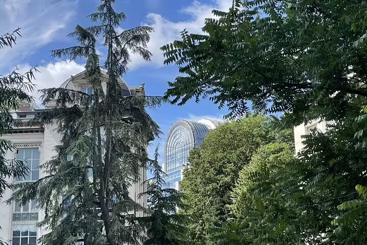 European Quarter Brussels skyline with modern EU glass building seen through leafy park on private walk