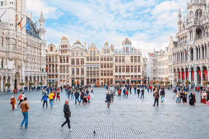 Visitors explore the stunning Grand Place in Brussels during a private tour featuring hidden gems and a refreshing beer stop.