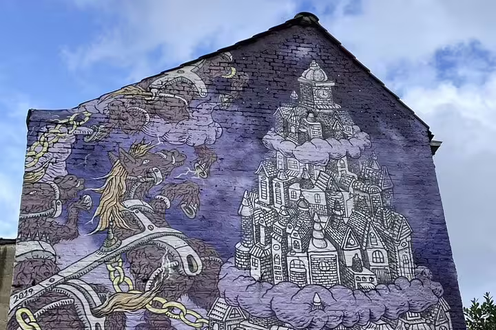 Brussels street art mural of fantasy city and dragon, a creative stop on a private European Quarter walk