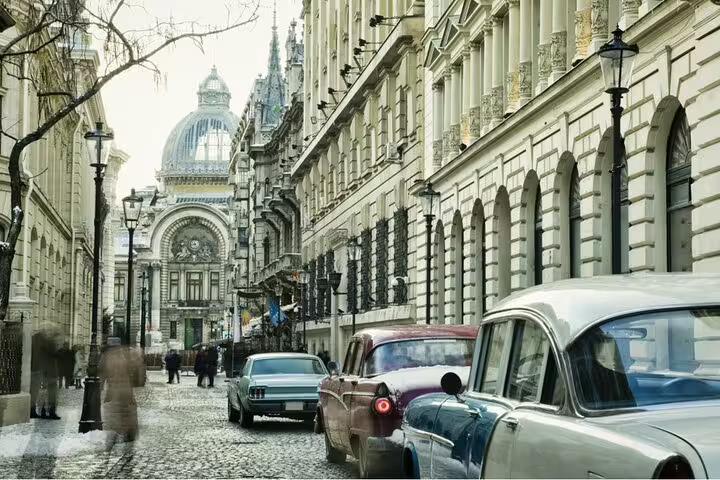 Historic cobblestone street in Bucharest with classic cars and ornate communist-era buildings