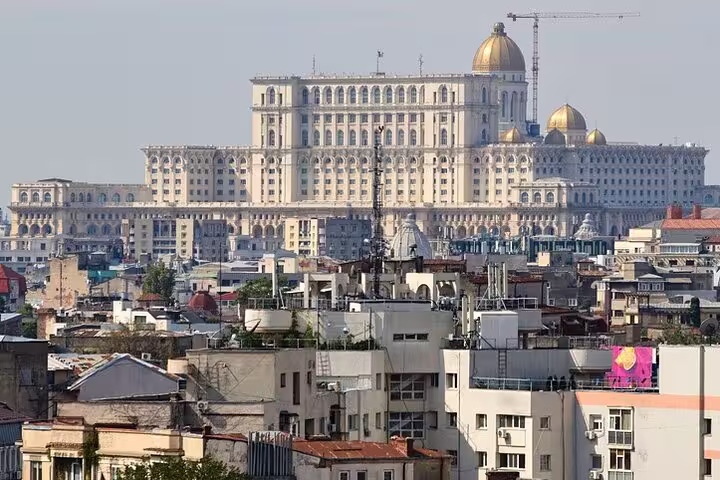 Skyline view of Bucharest with the grand Palace of Parliament towering above city rooftops, ideal for walking tours.