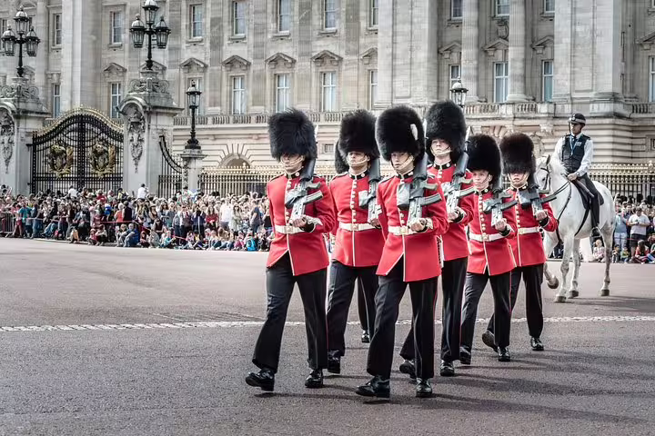 Buckingham Palace guards in iconic red uniforms perform the Changing of the Guard ceremony during a London Highlights Bike Tour.
