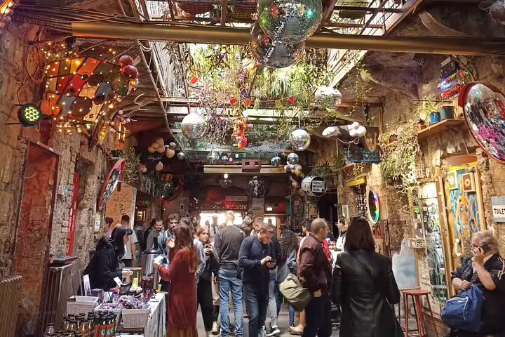 Crowded Budapest ruin bar interior with disco balls, street art, and lights, ideal for a ruin bars walking tour
