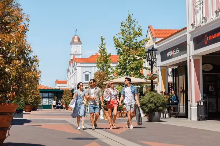 Friends shopping at Parndorf Outlet Village on Budapest to Vienna private transfer, designer stores and cafes