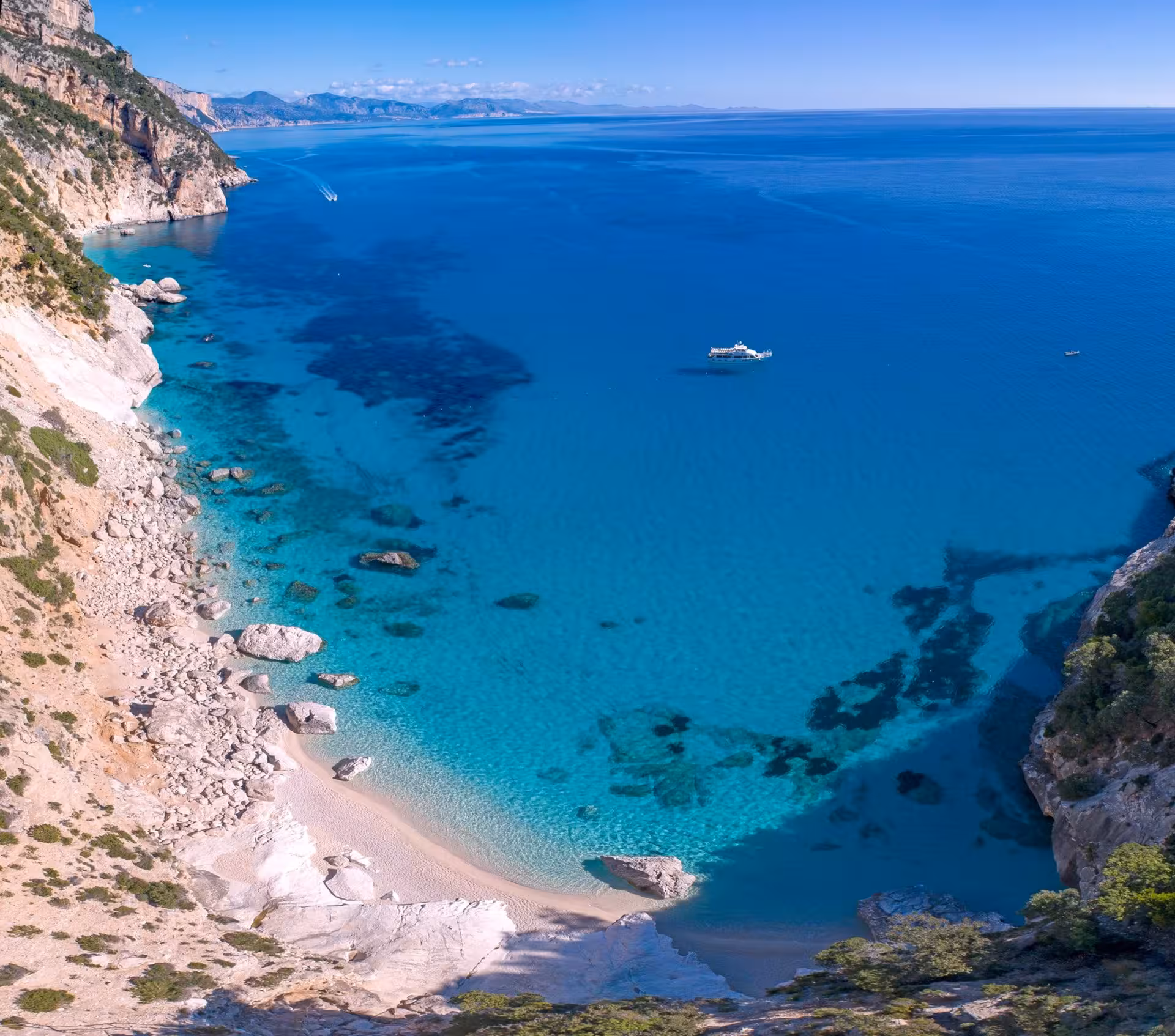 Aerial view of pristine Bue Marino Caves coastline, featuring turquoise waters and secluded sandy beach.