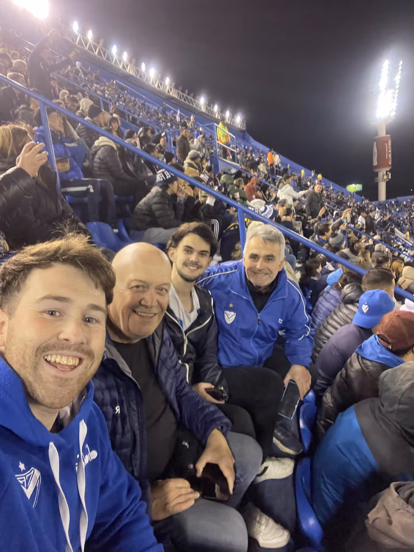 Fans selfie in packed Buenos Aires stadium stands during local soccer matchday experience with a guide