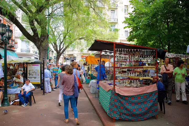 Street market in Buenos Aires with artisan stalls and locals, ideal stop on a private half-day sightseeing tour