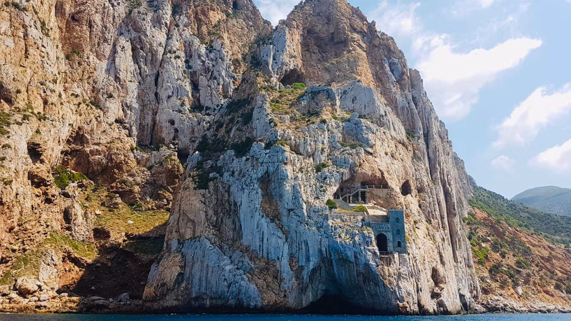 Discover the rugged beauty of Porto Flavia's cliffs, a highlight on the Buggerru dinghy tour to Sardinia's coastline.