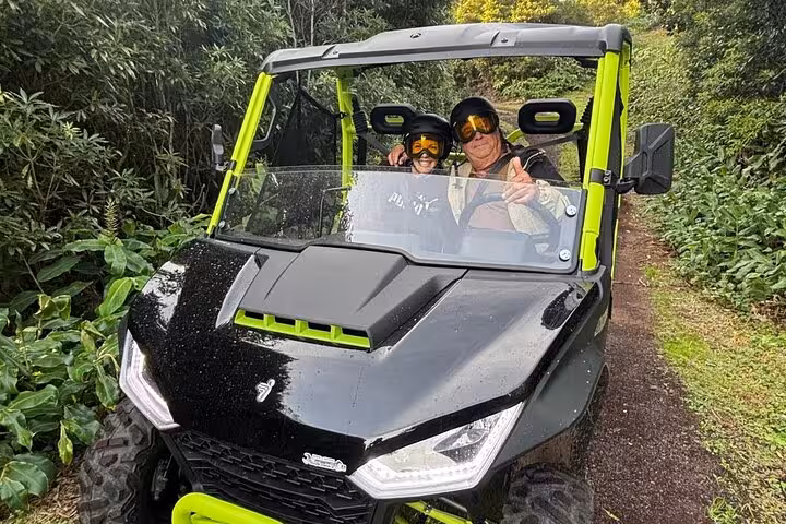 Two adventurers in a buggy explore lush trails on Mount Pico, perfect for thrilling scenic tours in the Azores.