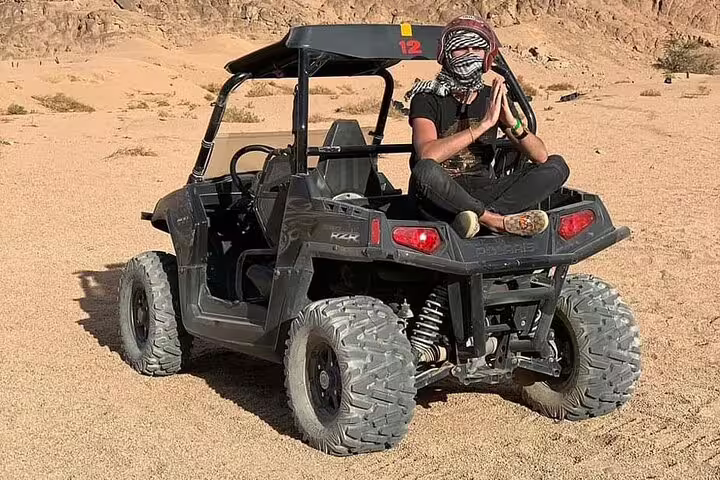Traveler on UTV during double buggy adventure desert safari from Sharm El Sheikh, Sinai sand and rocky hills