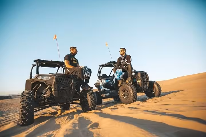 Two dune buggies parked on golden desert dunes during Buggy Safari in Sharm El Sheikh, Sinai at sunset
