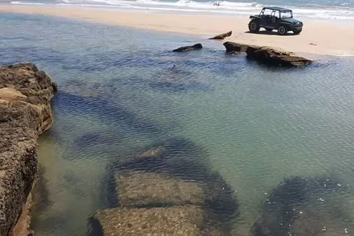 4x4 buggy by natural pools and rocks at Águas Belas beach, Ceará, on a scenic off-road tour