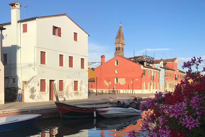 Colorful canal view in Burano with traditional boats and vibrant houses, perfect for a Private LimoBoat tour.