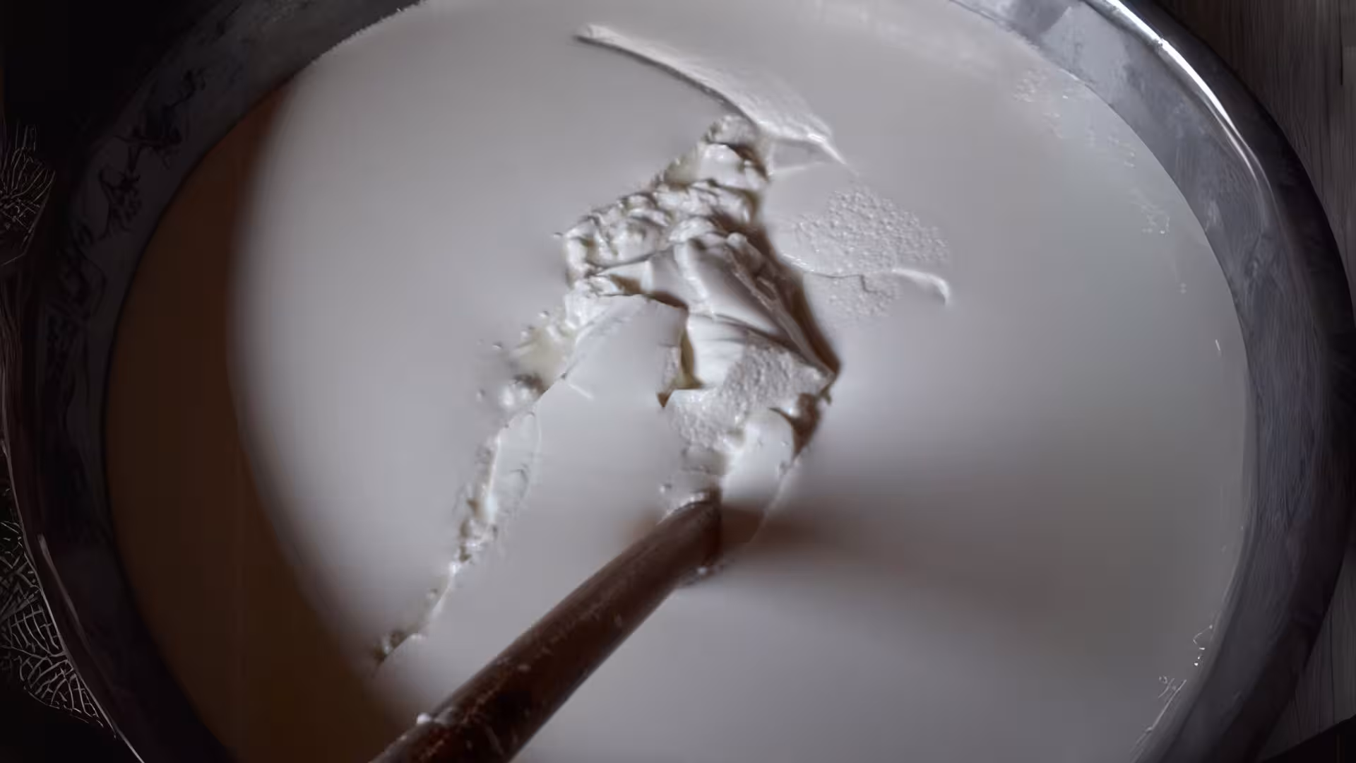Milk curds forming in a large vat during a hands-on pecorino cheese workshop in Burgos.