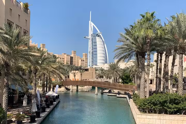 Burj Al Arab view from Madinat Jumeirah canal with palms, highlight of Dubai historical and modern tour