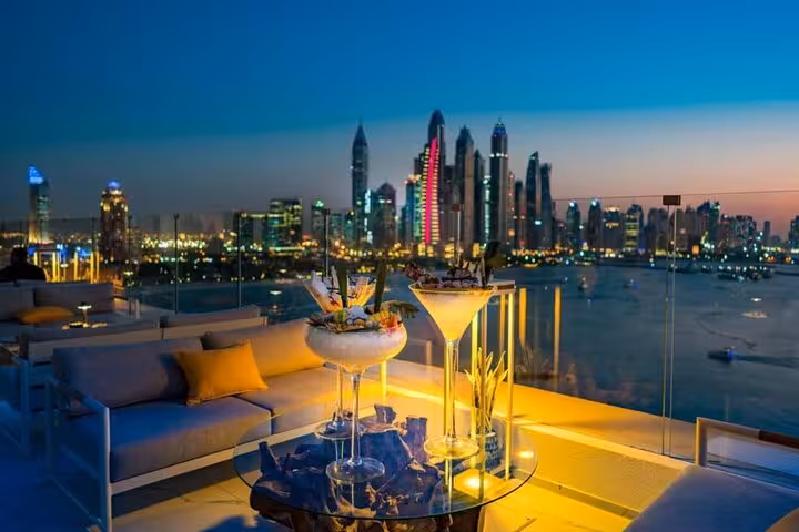 Dubai Marina rooftop meal with skyline at night, ideal with Burj Khalifa ticket for rooftop dining experience