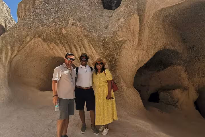 Guests posing by Cappadocia cave formations on a business class Cappadocia tour by plane day trip