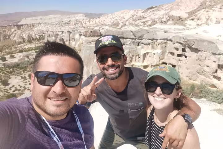 Group selfie overlooking Cappadocia rock valleys on business class flight tour, Göreme panoramic view