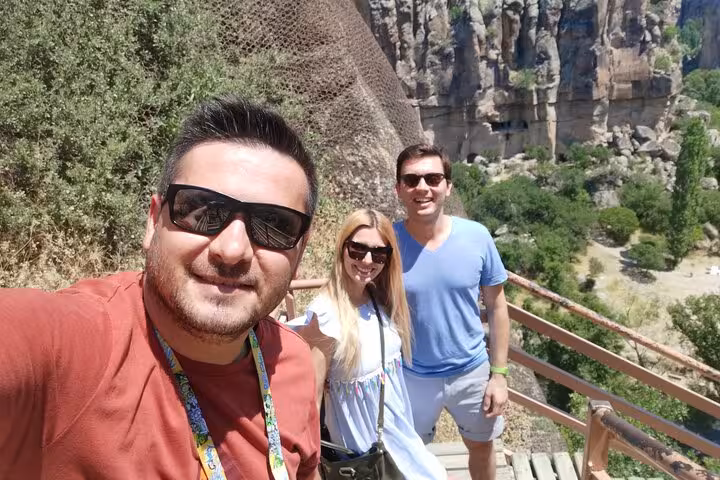 Travelers on walkway with Cappadocia cliffs and greenery, business class Cappadocia tour by plane