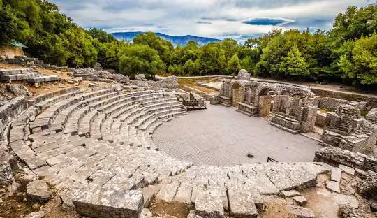 Explore the ancient amphitheater of Butrint, Albania, surrounded by lush greenery and rich historical significance.