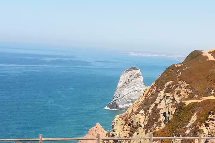 Breathtaking view of the rocky cliffs at Cabo da Roca with the Atlantic Ocean in the background on a clear day.