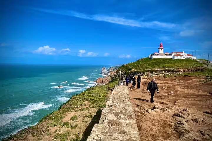 Visitors explore the stunning coastal views at Cabo da Roca during the Sintra & Cascais Hidden Gems Private Tour with Wine Tasting.