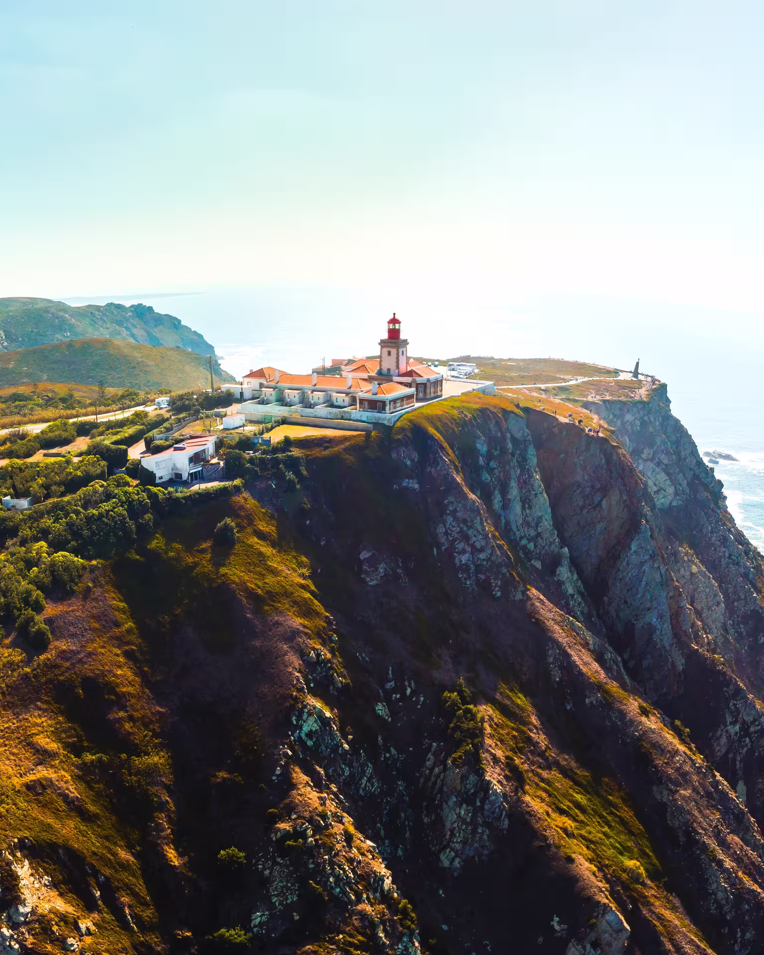 Aerial view of Cabo da Roca lighthouse perched on cliffs, showcasing stunning ocean vistas on Sintra to Cascais tour.