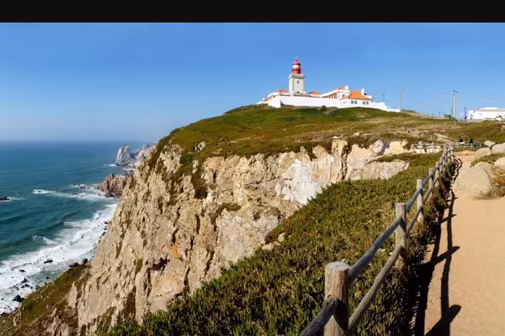 Scenic view of Cabo da Roca lighthouse perched on rugged cliffs overlooking the Atlantic Ocean.