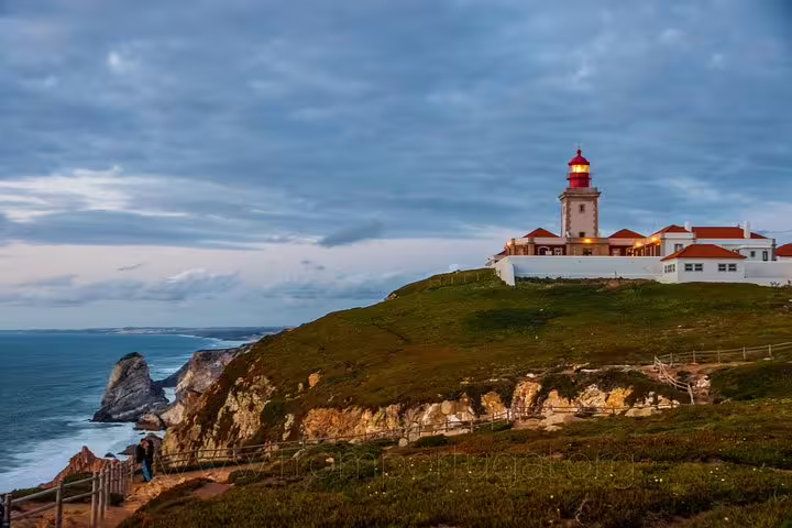 Scenic view of Cabo da Roca lighthouse perched on a cliff at sunset, a highlight of Portugal tours from Lisbon.