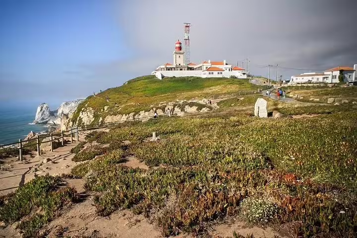 Scenic view of Cabo da Roca lighthouse on the Sintra & Cascais Full-Day Tour, capturing the rugged coastal landscape and ocean.