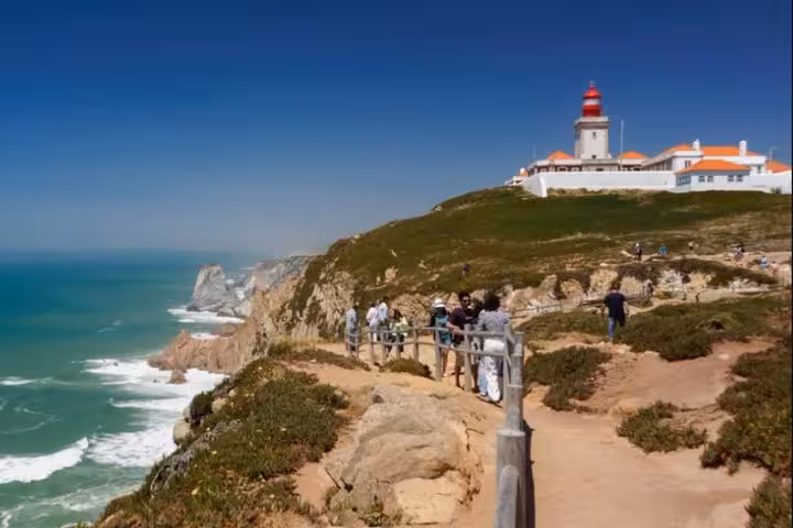 Scenic view of Cabo da Roca lighthouse perched on rugged cliffs overlooking the Atlantic Ocean, a highlight of the private tour.