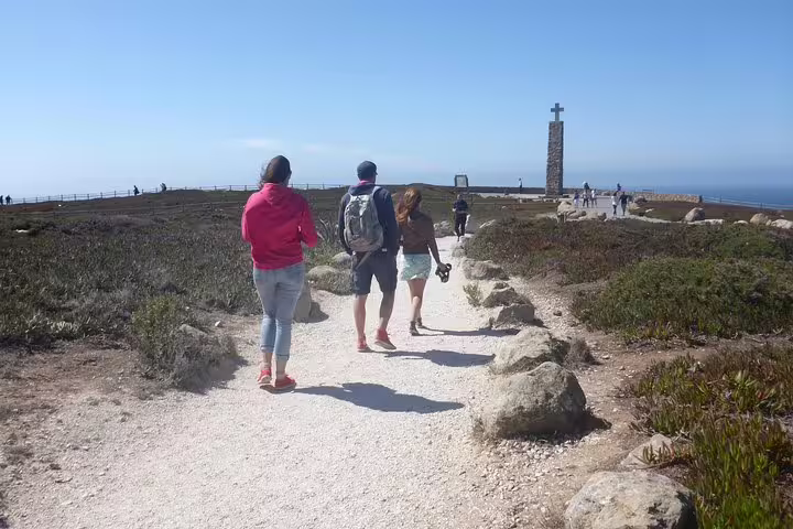 Travelers explore the scenic coastal path at Cabo da Roca, the westernmost point of mainland Europe, during a Sintra and Cascais tour.