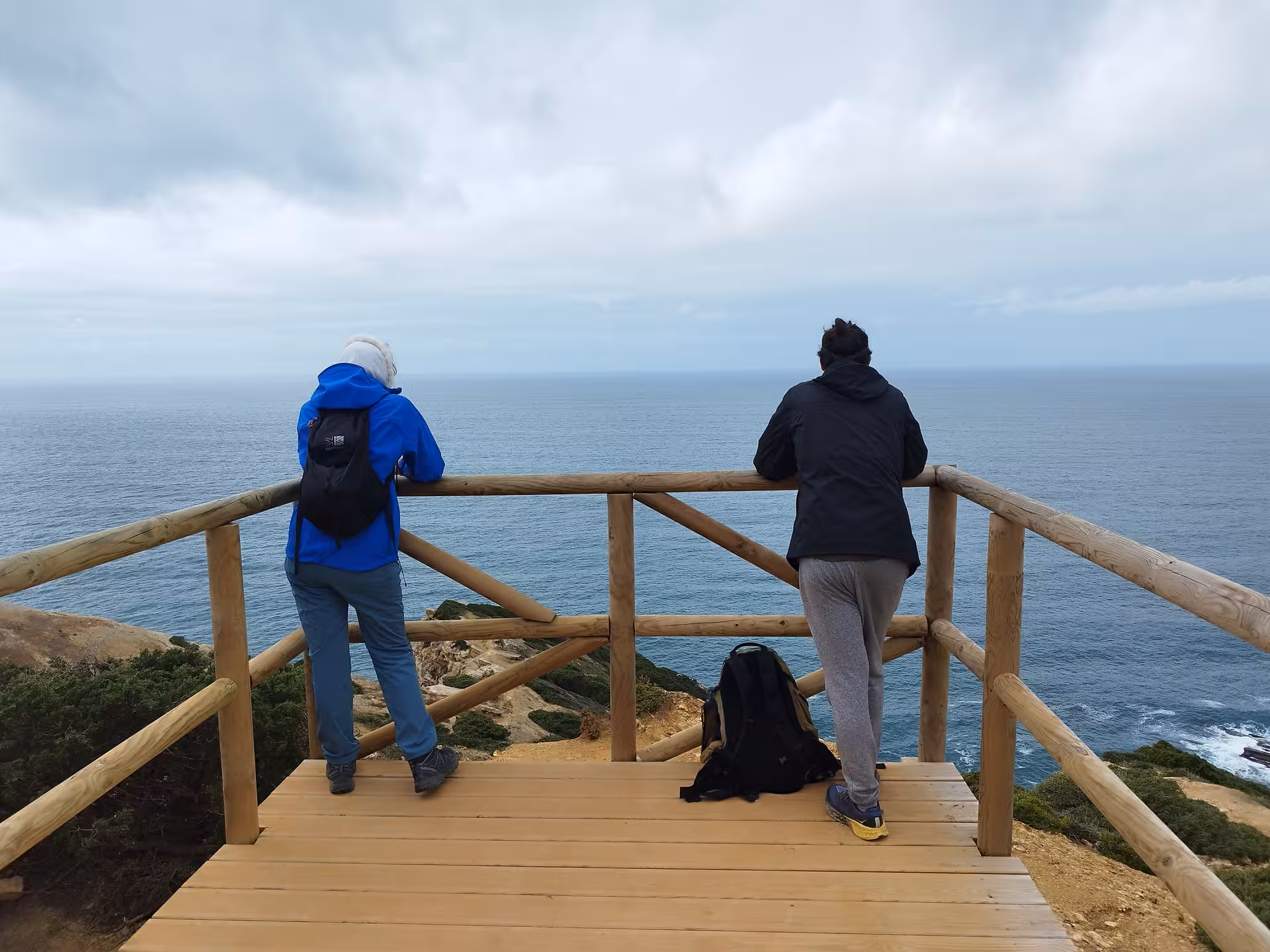 Hikers on a cliff viewpoint at Cabo Espichel, Portugal, on the dinosaur footprints coastal hike tour
