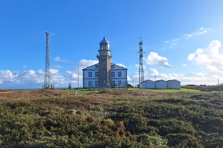 Cabo Peñas Lighthouse standing majestically under a bright sky, a key highlight of the Oviedo coastal tour.