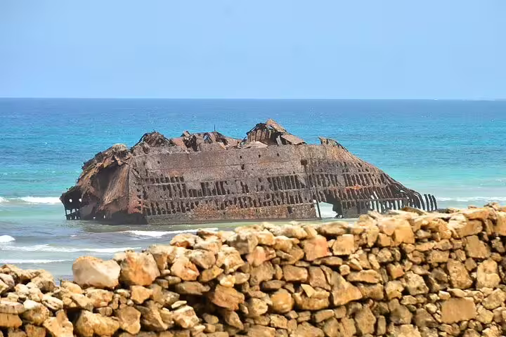 The shipwreck of Cabo Santa Maria rests on the shore, a historic landmark against Boa Vista Island's turquoise waters.