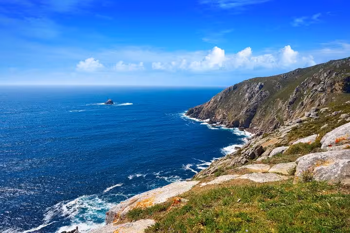 Breathtaking view of rocky cliffs and blue ocean at Cabo Vilan, a highlight of the Finisterre and Muxia boat excursion.