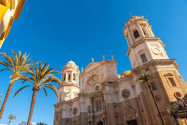 Historic Cadiz Cathedral under a clear blue sky, showcasing its stunning baroque architecture.
