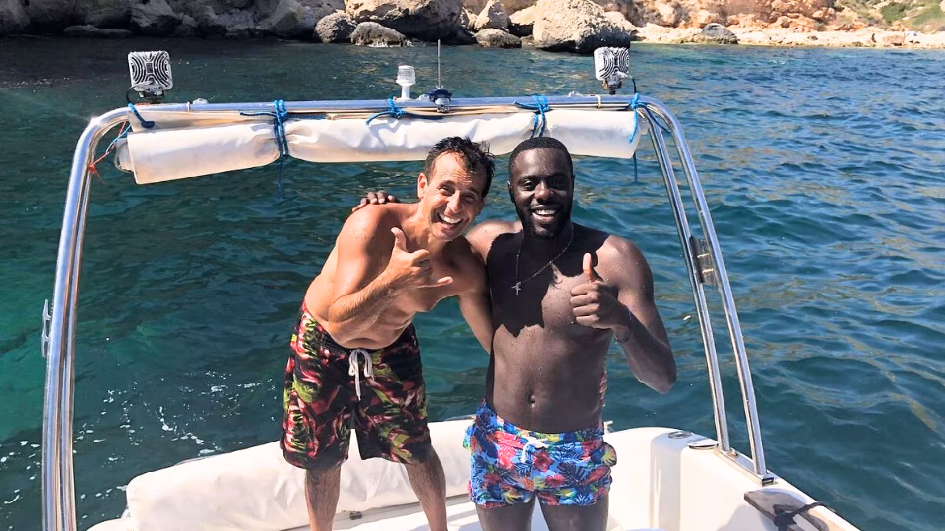 Two happy tourists enjoy a sunny day on a boat tour in Cagliari, preparing for a snorkeling experience.