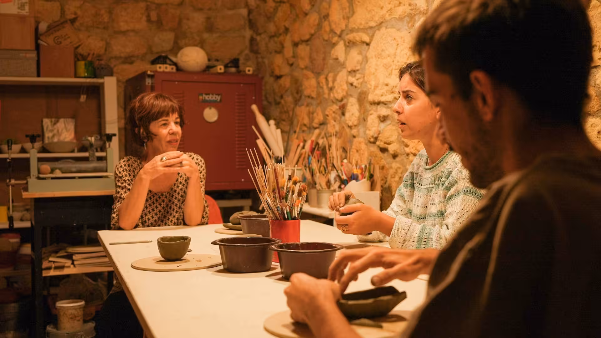 Participants engaging in creative pottery session at Cagliari ceramics workshop, fostering artistic community.