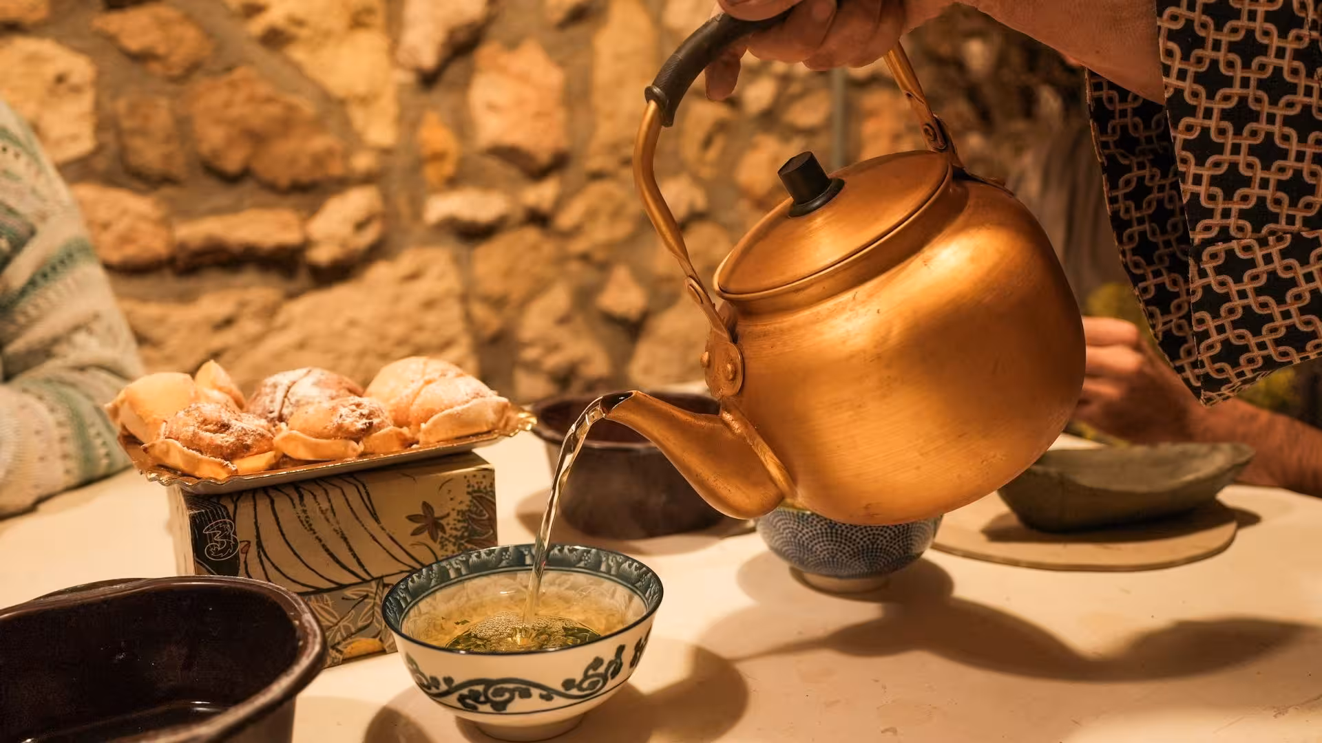 Pouring tea into a handmade ceramic bowl during a Cagliari ceramics workshop experience.