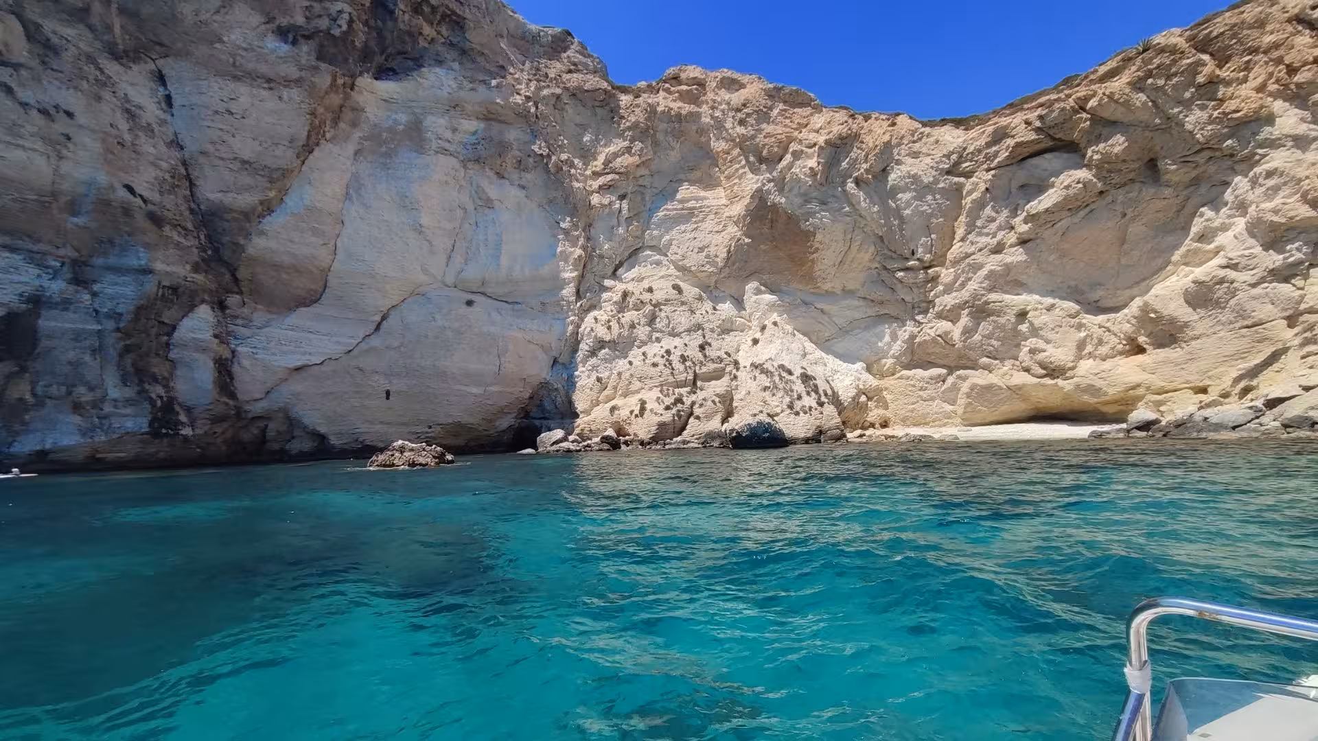 Close-up of Cagliari's dramatic cliffs meeting the turquoise sea, ideal for a scenic dinghy tour experience.
