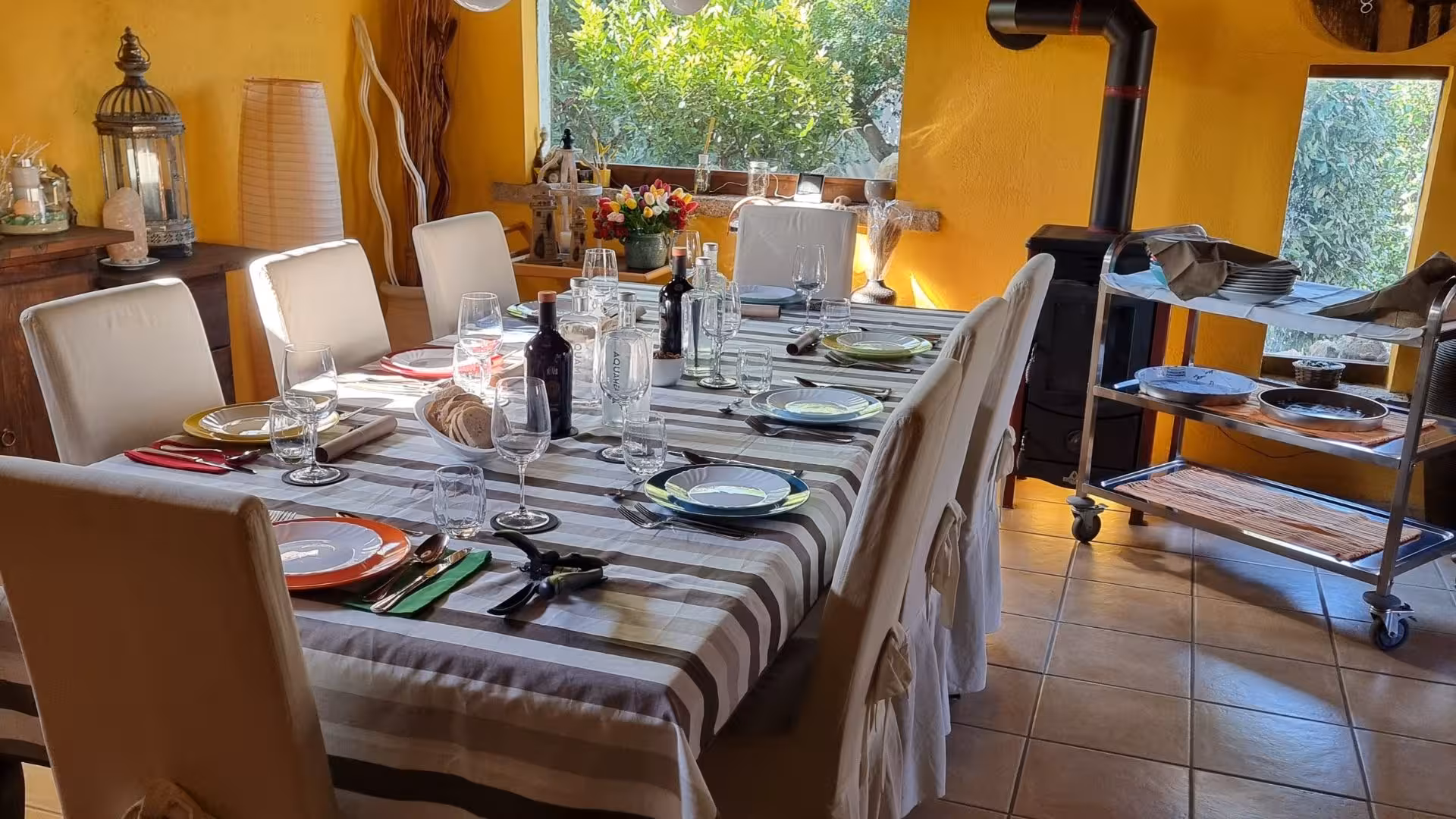 Elegant dining setup with colorful plates and wine bottles in a cozy room for Cagliari culurgiones workshop.