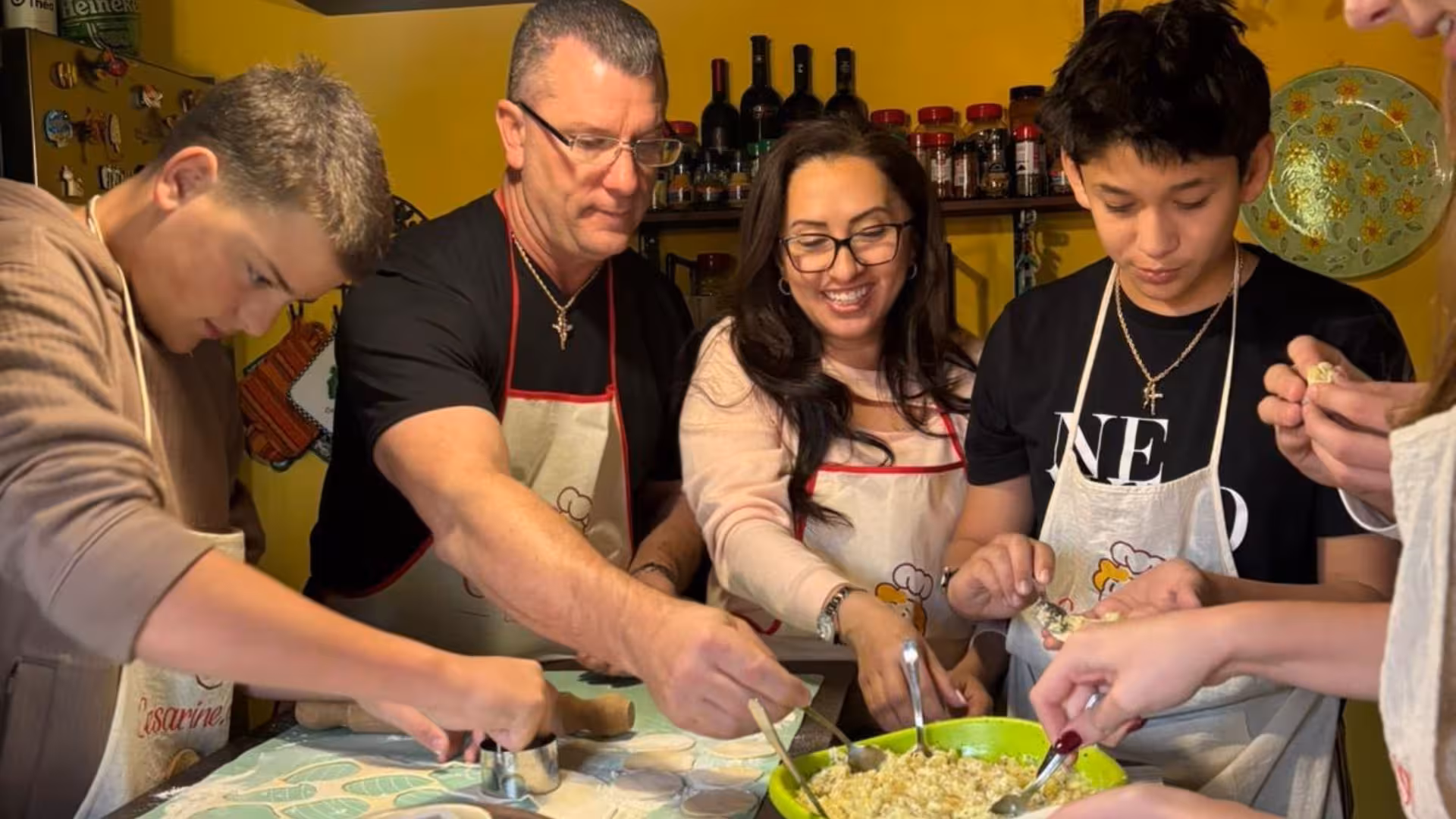 Participants in aprons crafting traditional culurgiones during a vibrant workshop in Cagliari.
