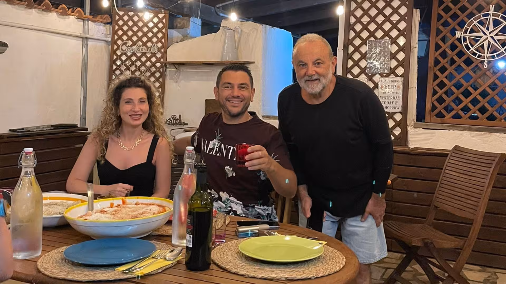 Group enjoying a traditional Italian meal at a Cagliari culurgiones workshop with vibrant dishes and drinks.
