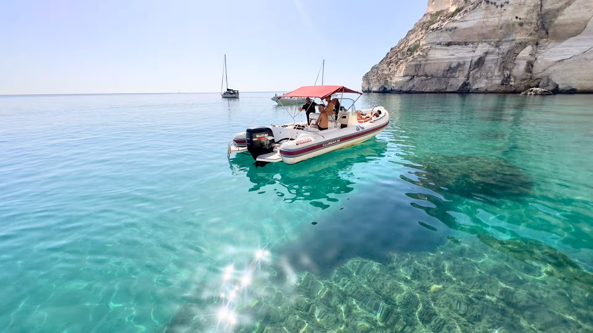 Dinghy anchored in crystal-clear waters during Cagliari snorkeling adventure.
